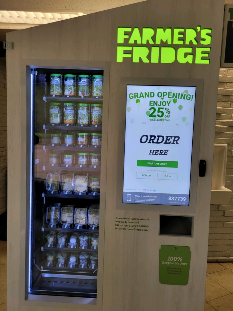 Photo of a vending machine with green neon lights which reads